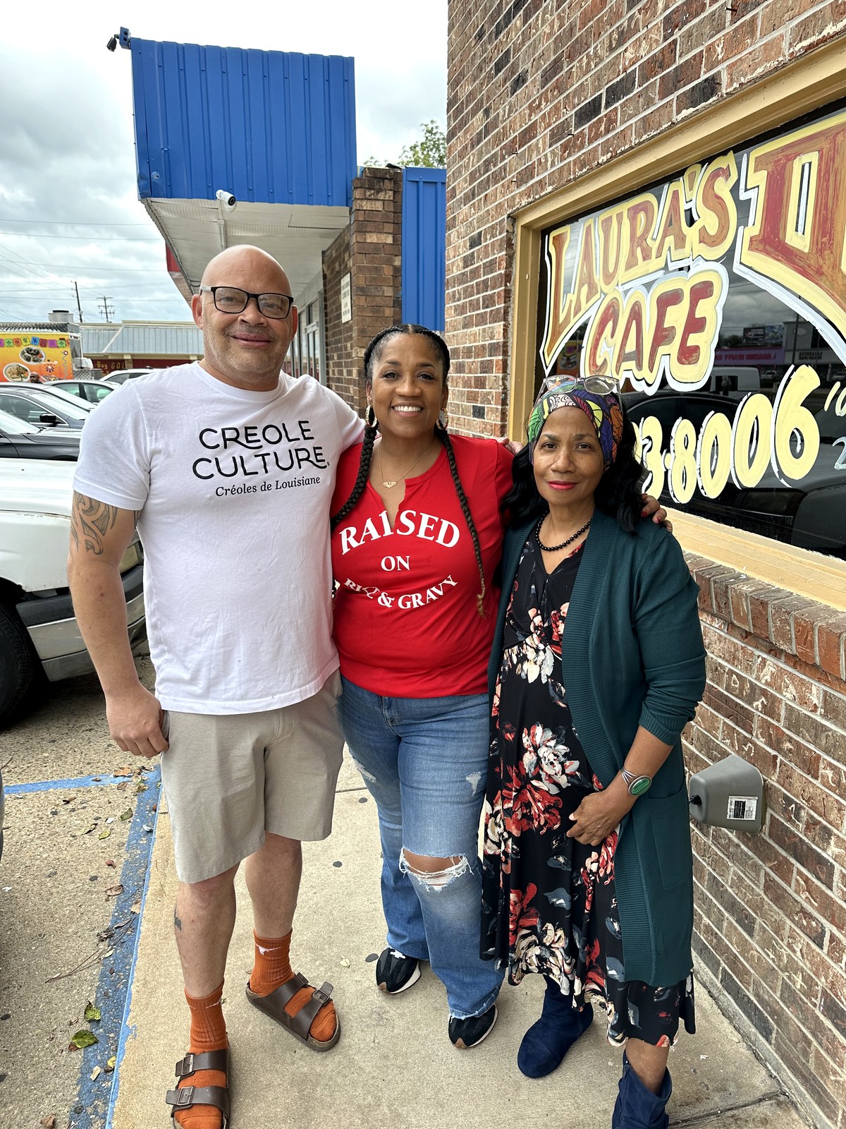 Ruth Foote, at right in a headwrap and floral dress, with Milton Arceneaux outside Laura&rsquo;s II Caf&eacute; in Lafayette