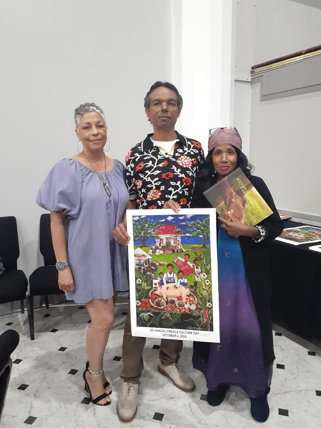 Joey Benoit, Bryant Benoit holding the poster he created for the 4th Annual Creole Culture Day, and Ruth Foote holding the Hands of Heritage book