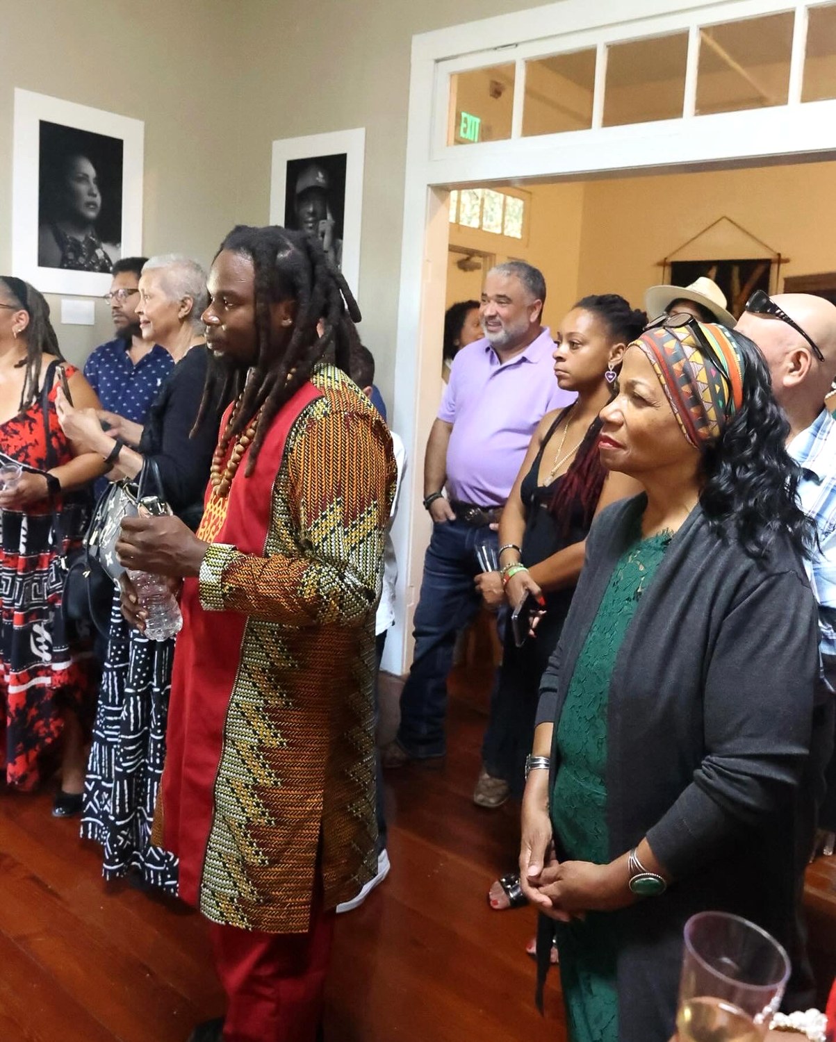 Ruth Foote, at right in a green dress and headwrap, among guests at a gallery opening