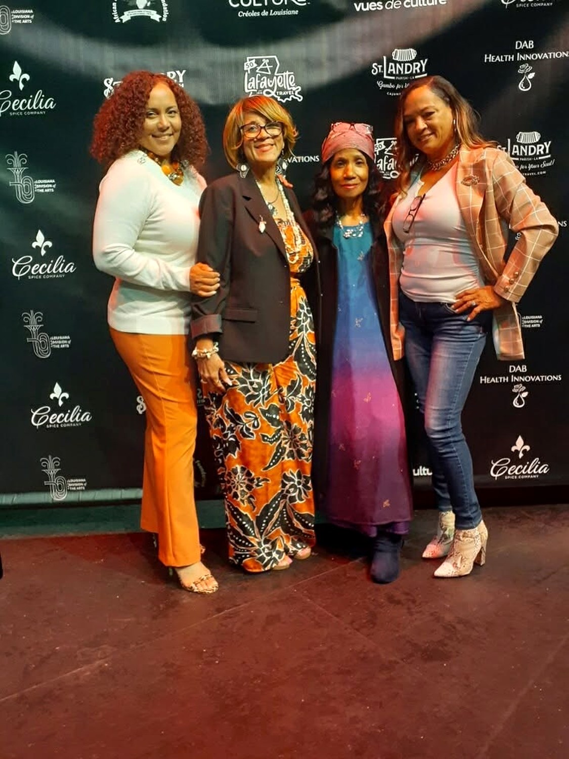 Ruth Foote with others at a Vues de Culture event in front of a sponsor backdrop